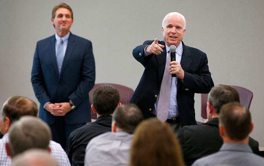 Sen. John McCain, R-Airz., right, points to an audience member who has a question as he and Sen. Jeff Flake, R-Ariz., hold a town hall meeting in Mesa, Ariz.