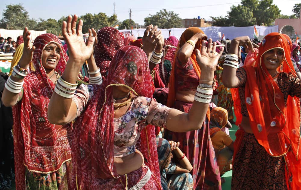 Indian women dressed in traditional attire dance during a public rally organized ahead of elections in the western Indian state of Rajasthan, in Pushkar.
