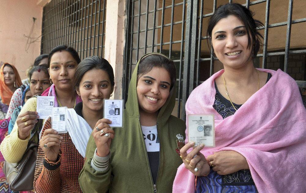 Woman voters show their voter identity cards at a polling station before casting their votes for Assembly elections in Bhopal, Madhya Pradesh.