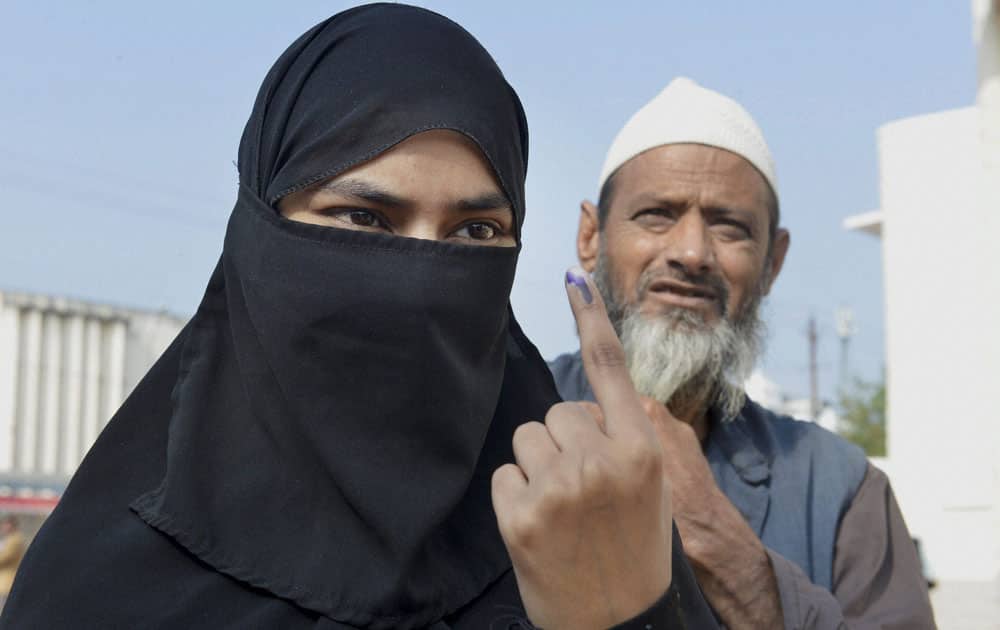 A woman voter shows her ink=-marked finger at a polling station after casting her vote for Assembly elections in Bhopal.