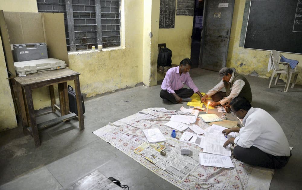 Polling employees arrange their materials in a polling booth on the eve of Madhya Pradesh Assembly Election, in Bhopal.