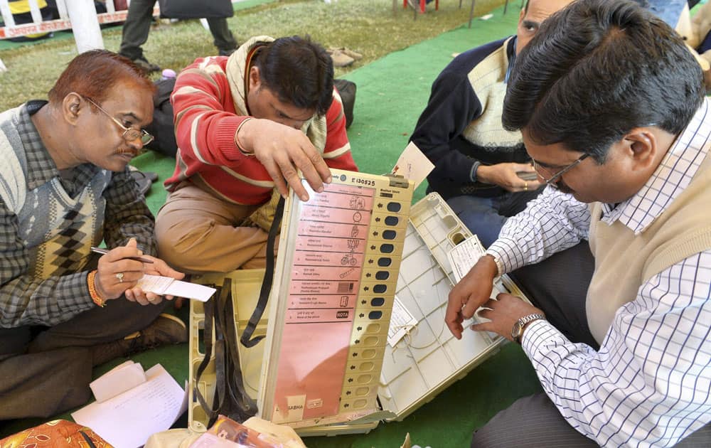 Poll officials check Elctronic Voting Machines (EVM) and other election materials distributed to them before Madhya Pradesh state assembly elections in Bhopal.