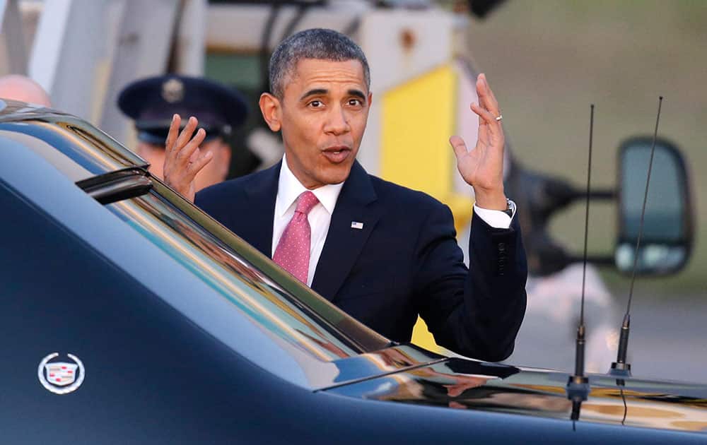 President Barack Obama motions toward media members after arriving at Seattle-Tacoma International Airport in Seattle.