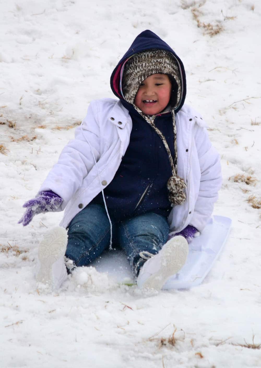 A youngster takes advantage of fresh snow to slide down a hill at Cameron University in Lawton. About three inches of snow fell in and around the Lawton area.