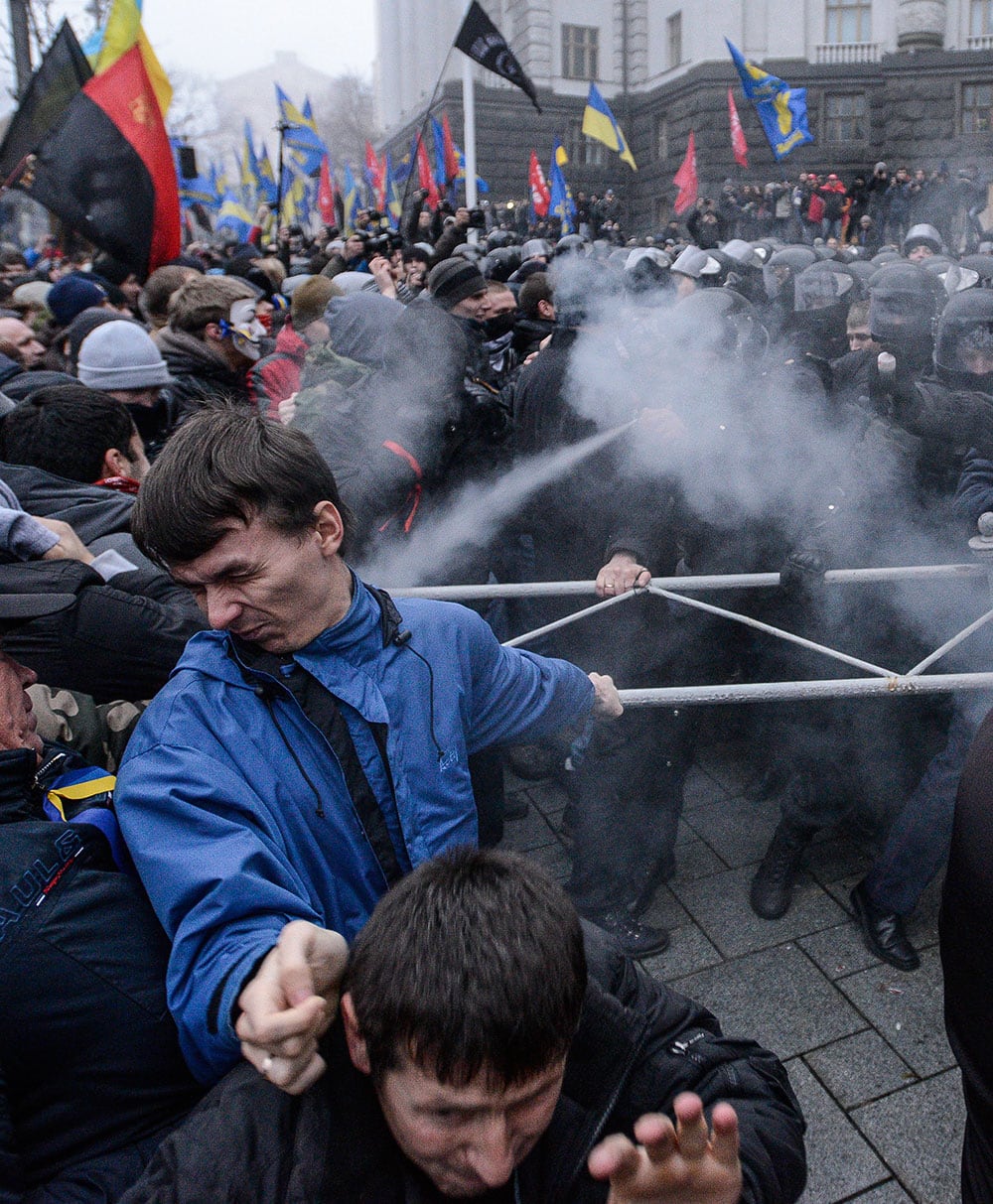 Opposition protesters and riot police fight in front of the Ukrainian Cabinet of Ministers in Kiev, Ukraine.