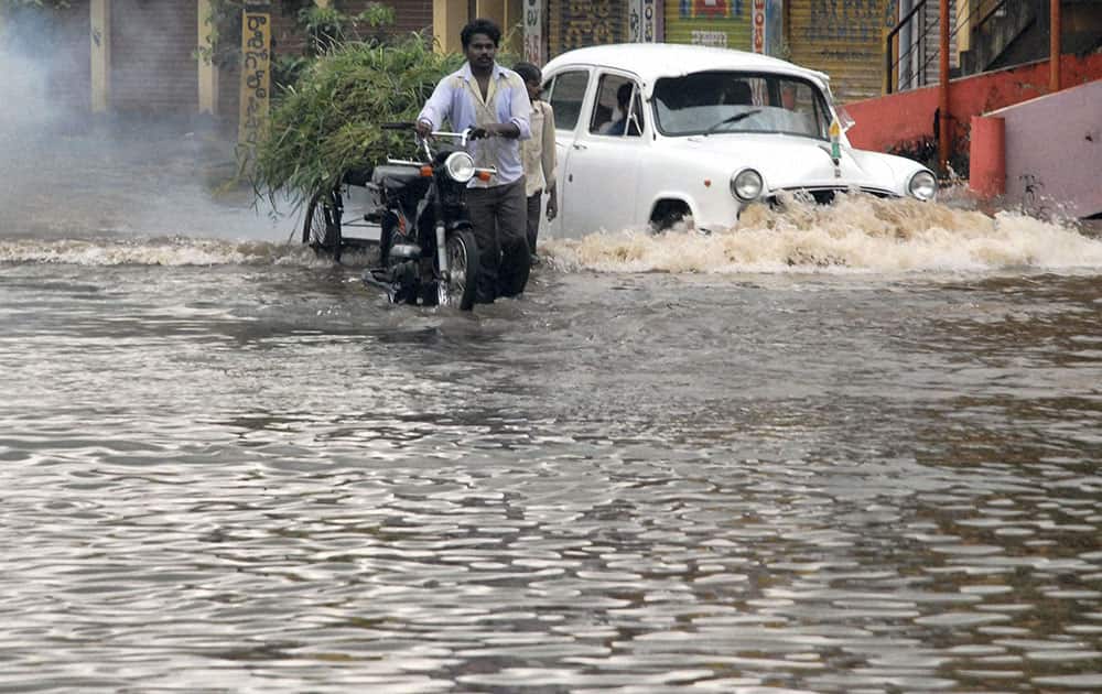 Vehicle move in rain water staginated in Vijayawada-Nuzvidu national highway in Vijayawada on Saturday, due to Helen cyclone in various parts of Andhra Pradesh.