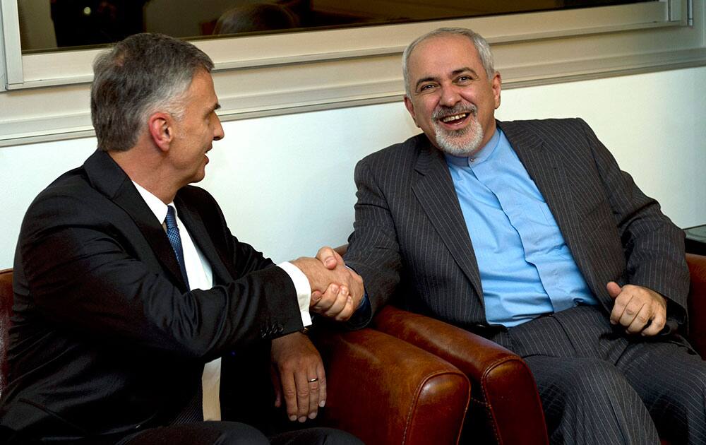 Switzerland`s Foreign Minister Didier Burkhalter, left, shakes hands with Iranian Foreign Minister Mohammad-Javad Zarif, during a meeting at the Intercontinental Hotel prior to talks about Iran`s nuclear programme in Geneva, Switzerland.