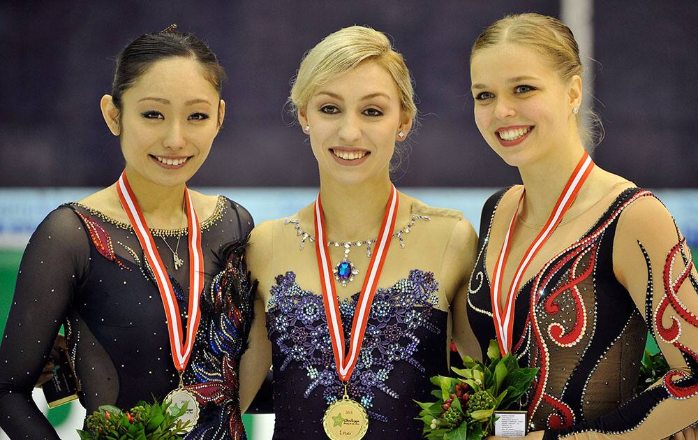 Miki Ando of Japan, left second place, Courtney Hicks of US, center first place and Anita Madsen of Denmark, right third place, during the flower ceremony after the free program at the Ice Challenge 2013 International Figure Skating Competition in Graz, Austria.