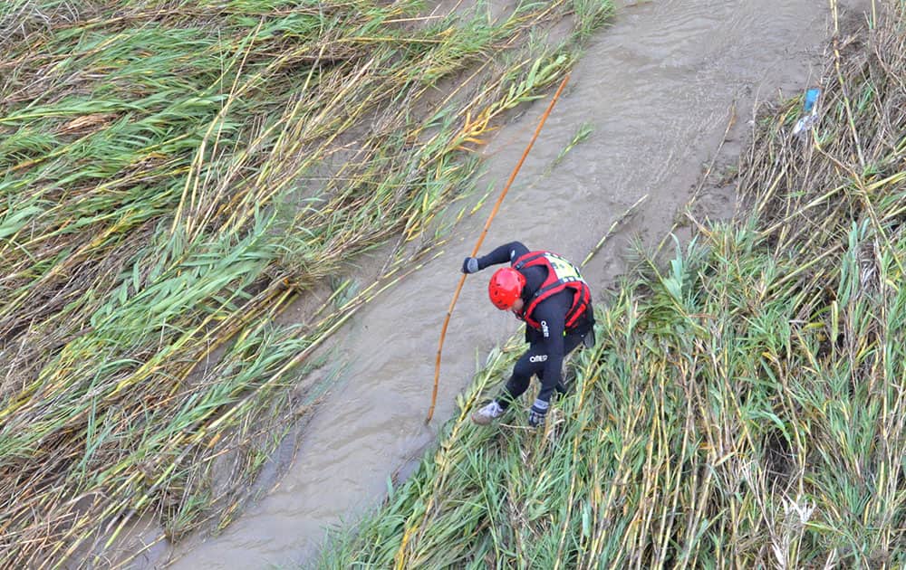 A rescuer searches for a missing person at the South-East Island of Rhodes, Greece. Authorities say there are deaths reported after heavy rain struck the island of Rhodes in southeastern Greece, with many trapped in cars, according to the island fire brigade.