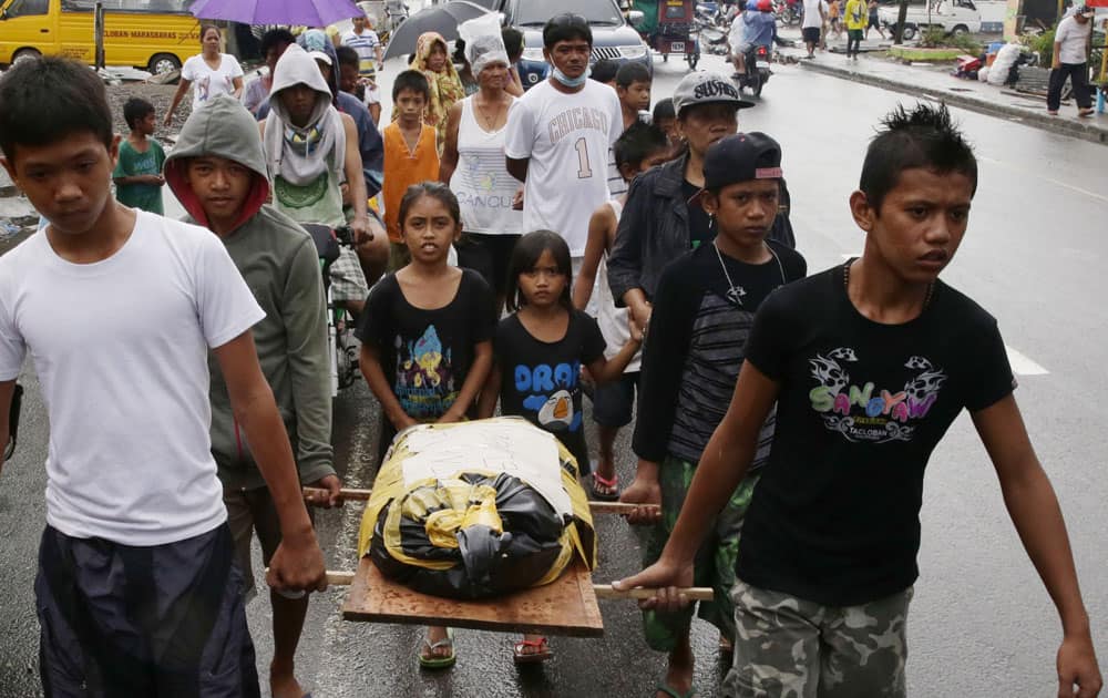 Relatives carry the body of three-year-old Athena Mae Pelingon for burial, at Tacloban city, Leyte province in central Philippines.