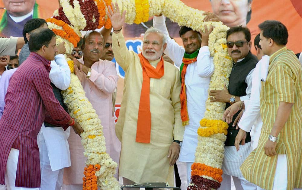 BJP Prime Ministerial candidate Narendra Modi is garlanded during an election rally in Khandwa, Madhya Pradesh.