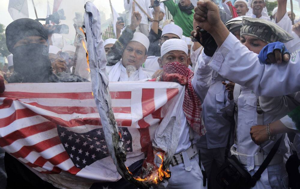 Members of the militant Islamic Defenders Front (FPI) burn a mock Australian and US flags during a demonstration outside Australian Embassy in Jakarta.
