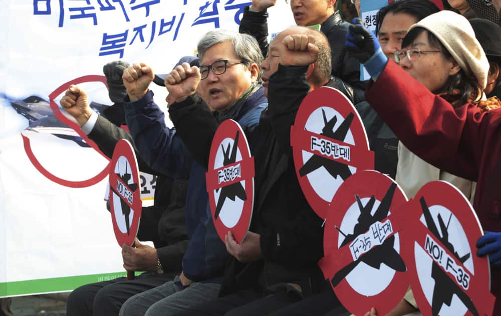 Protesters shout slogans during a rally against a meeting of senior military officers to choose South Korea`s next-generation fighter jets in front of the Defense Ministry in Seoul, South Korea.