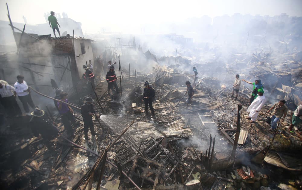 Residents try to salvage their belongings as firefighters try to douse a fire at the Ambedkar Nagar slum in Mumbai.