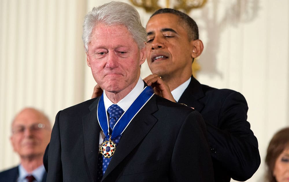 President Barack Obama awards former President Bill Clinton with the Presidential Medal of Freedom, during a ceremony in the East Room of the White House in Washington.