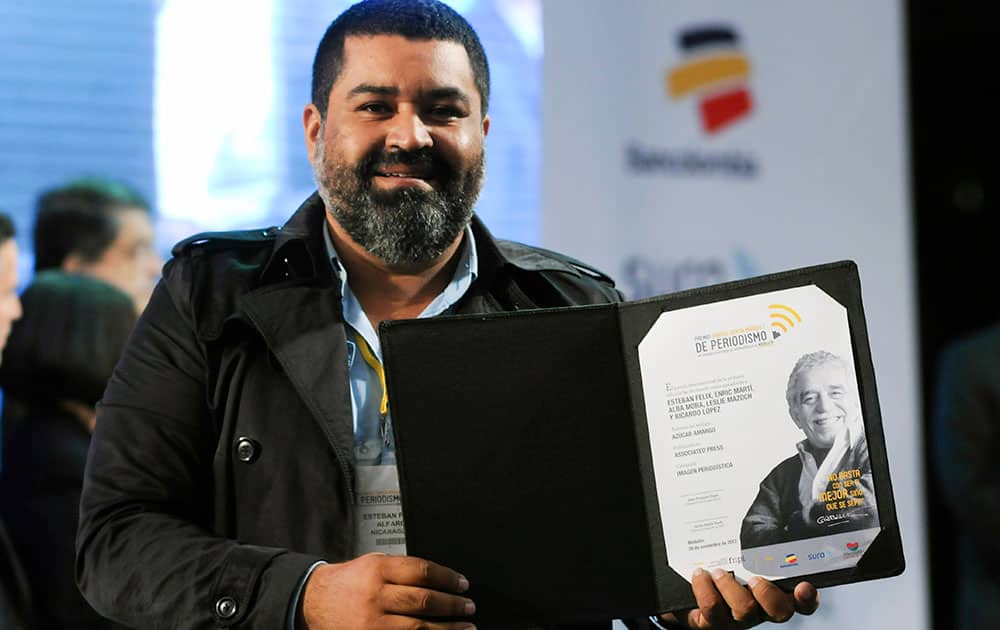 Esteban Felix, an Associated Press photographer from Peru who is based in Nicaragua, shows his Gabriel García Márquez International Journalism Award for visual journalism at the awards ceremony in Medellin, Colombia.