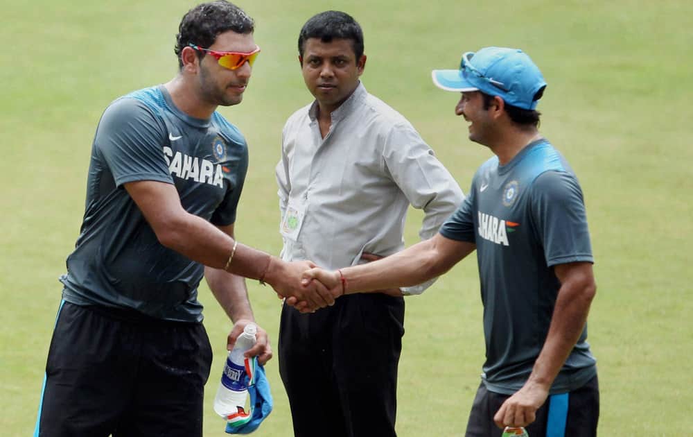Yuvraj Singh greets Mohit Sharma during a practice session on the eve of the 1st ODI against West Indies at Jawaharlal Nehru Stadium in Kochi.