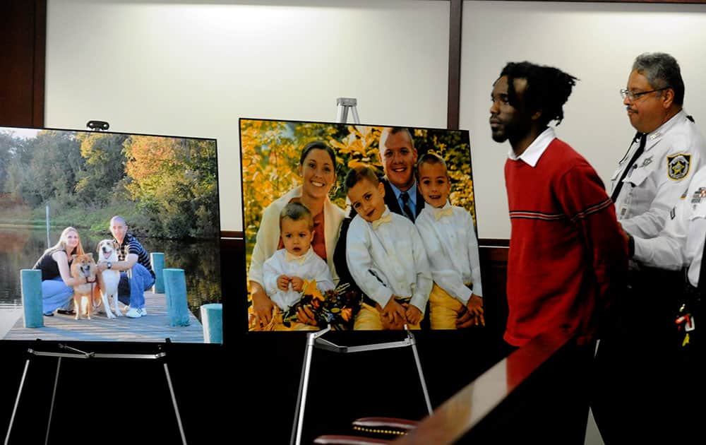 Dontae Morris is returned to the courtroom, walking past prosecution displays showing TPD officers David Curtis and Jeffrey Kocab and their families, after a break for the penalty phase of his trial before Circuit Judge William Fuente in the Hillsborough County Courthouse.
