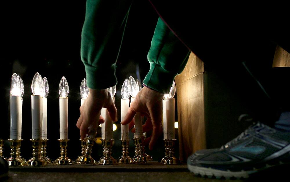 A death penalty opponent picks up a battery-powered candle outside St. Francis Xavier Church during a vigil in protest of the scheduled execution of death row inmate Joseph Paul Franklin.
