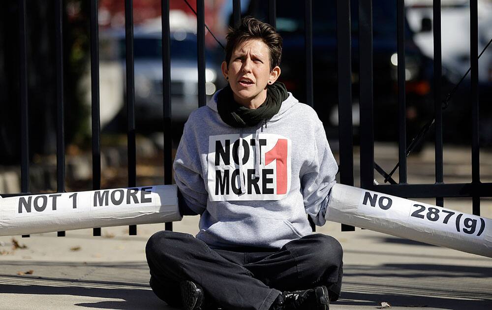 An Immigration activist, protesting deportations of people who are in the country illegally, blocks the front gate of a building that houses federal immigration authorities.