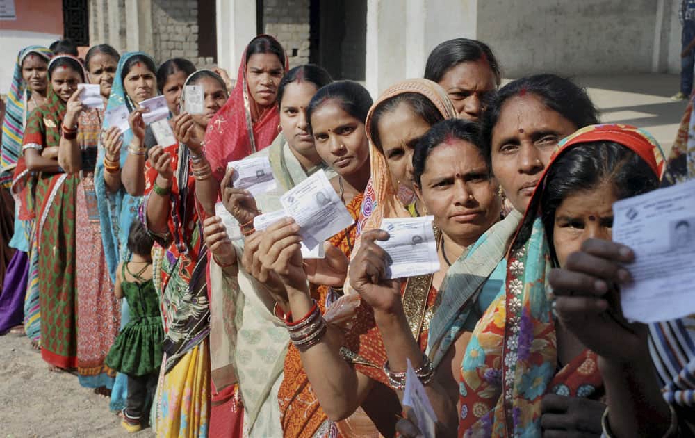 People queue outside the polling booth for casting their vote in the assembly election 2013 in Raipur.