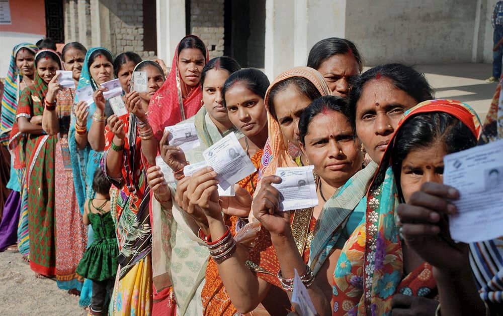 People queue outside the polling booth for casting their vote in the assembly election 2013 in Raipur.