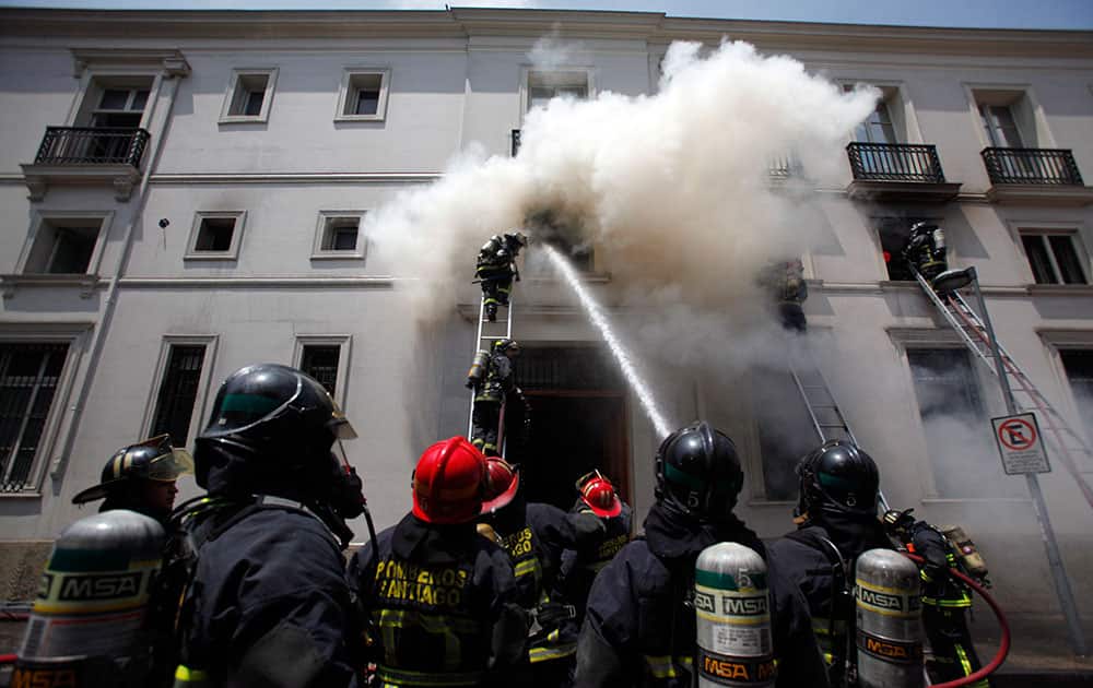 Firefighters work to extinguish a fire at the famed Municipal Theater in Santiago, Chile. The fire began in a warehouse that stores costumes and props for a production of The Nutcracker. Damage to the main part of the theater was still being assessed.