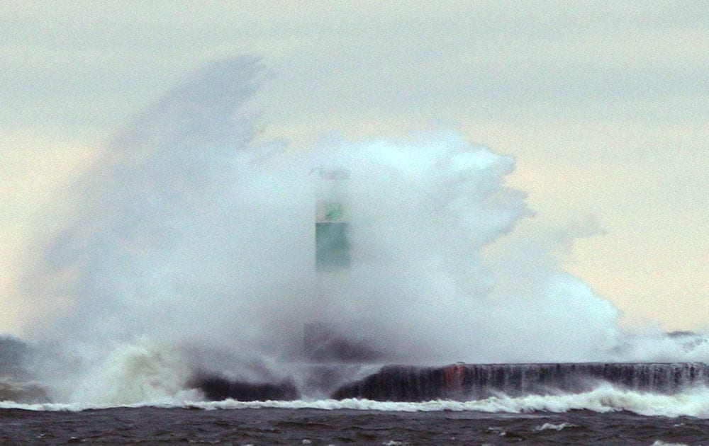 High winds contributed to the wave action on the Lake Michigan surf as waves crash over a lighthouse at the Muskegon Lake channel in Muskegon.