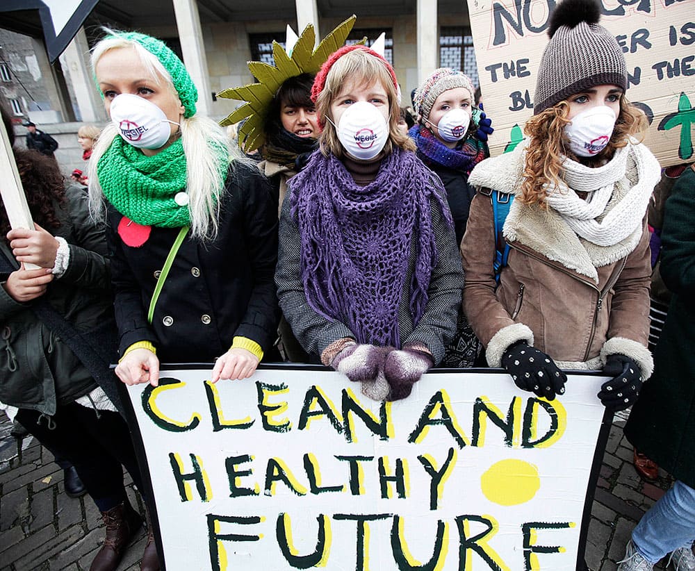 Young girls protest in front of the Polish Ministry of Economy in Warsaw, Monday Nov. 18, 2013 where a Coal Industry meeting is taking place in Warsaw, Poland.