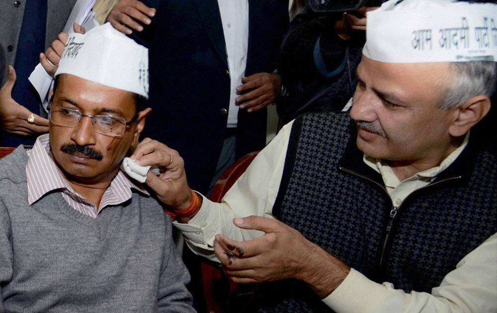 Aam Aadmi Party leader Manish Sisodiya cleans the face of party convener Arvind Kejriwal after a man threw black ink at him at a press conference in New Delhi.