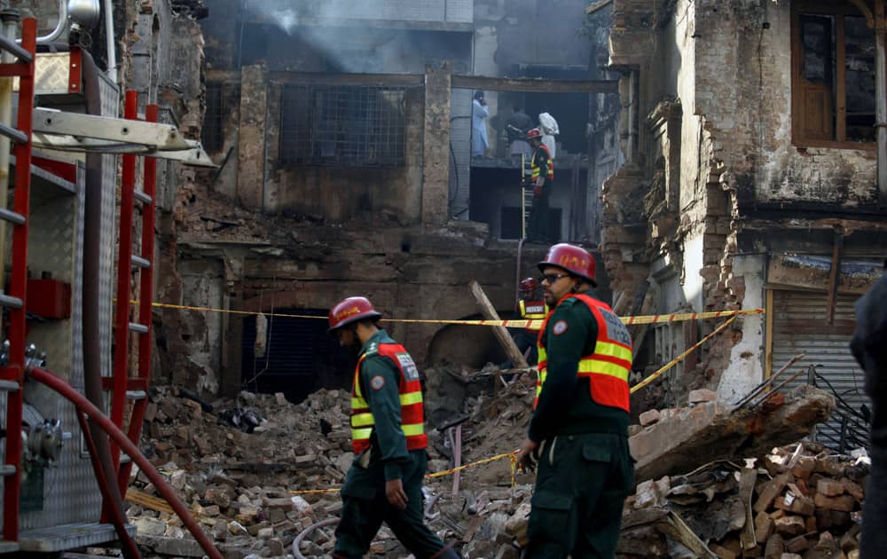 Pakistani rescue workers work in a burnt building, which was torched in the Friday`s sectarian clashes, in Rawalpindi.