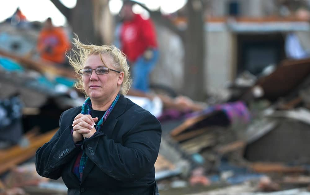 A resident of Washington, Ill., surveys the damage to her home and neighbors after a tornado and severe thunderstorms swept through a portion of the town.