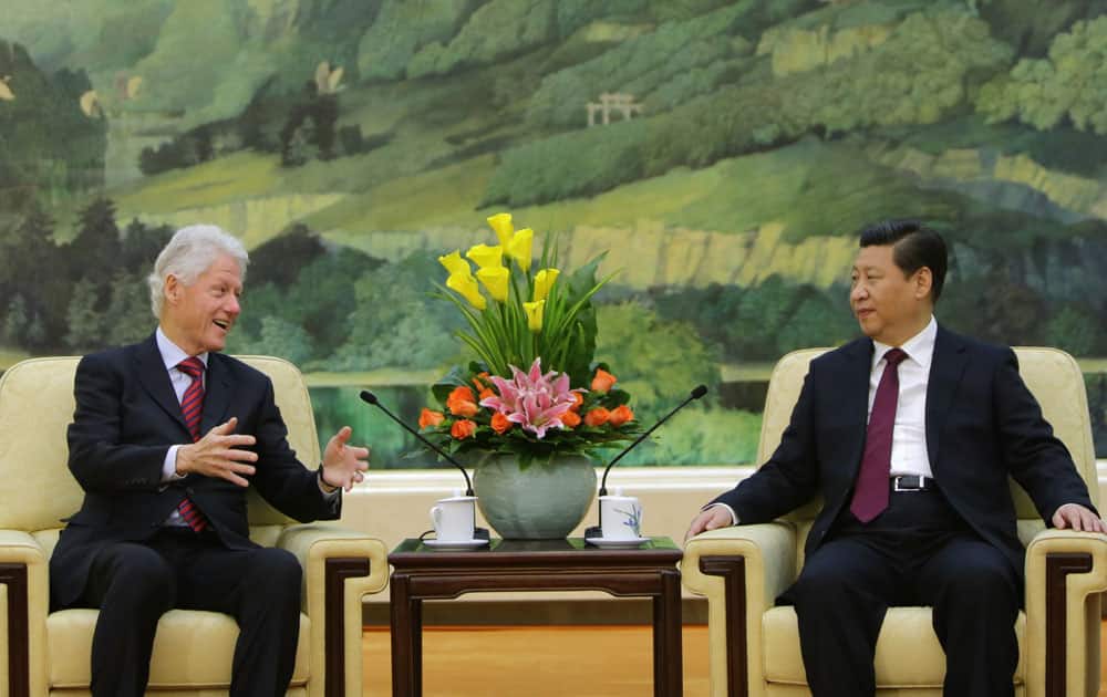 Former US President Bill Clinton, left, speaks to China`s President Xi Jinping during a meeting at the Great Hall of the People, in Beijing.