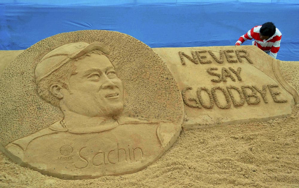 Sand artist Sudarsan Pattnaik giving final touches to the sand sculpture of Sachin Tendulkar at Cuttack in Odisha.