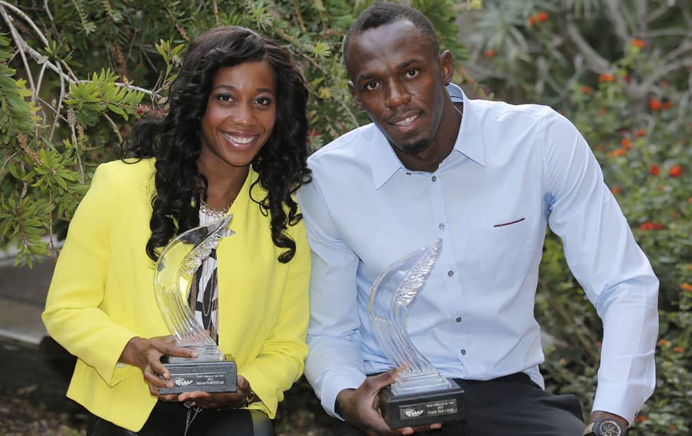 Jamaican sprinter Usain Bolt, right, and Jamaican track and field sprinter Shelly Ann Fraser Pryce hold their International Athletic Foundation