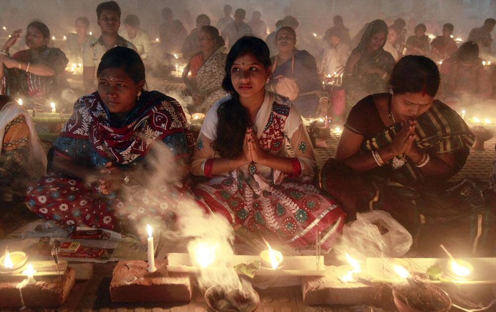 Bangladeshi Hindu devotees light lamps and offer prayers at a temple during Rakher Upabash in Narayanganj, near Dhaka, Bangladesh.