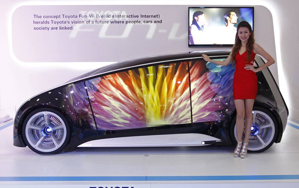 A model poses next to a Toyota Fun-Vii concept car on display at the Kuala Lumpur International Motor Show in Kuala Lumpur, Malaysia.