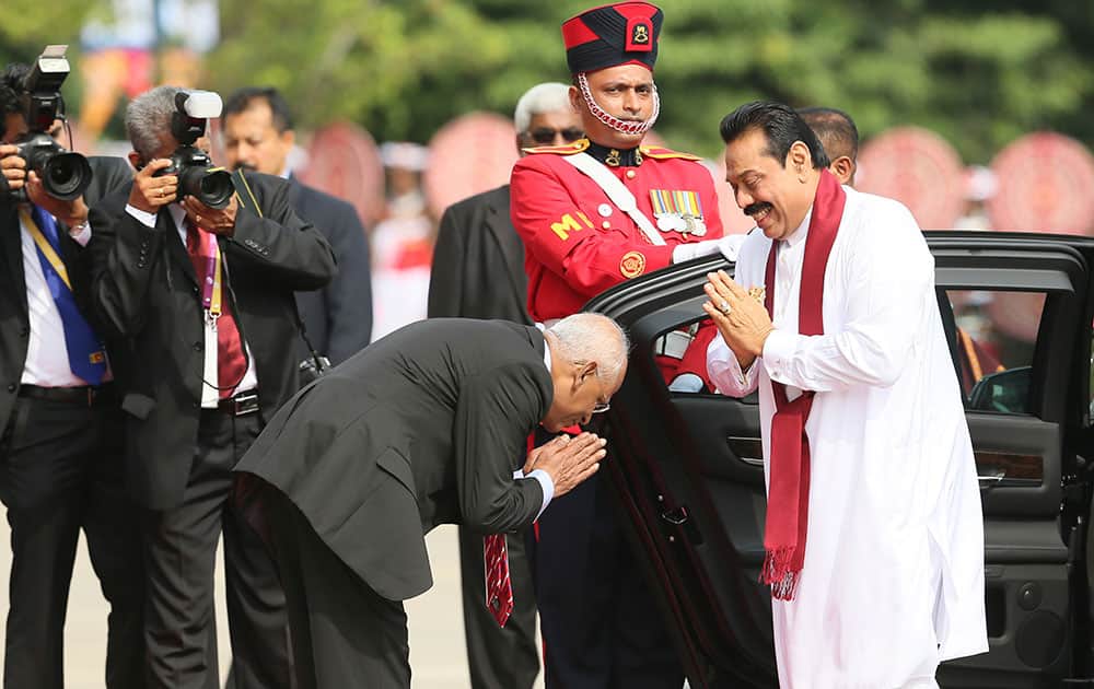 An official greets Sri Lankan President Mahinda Rajapaksa upon his arrival at the opening ceremony of the Commonwealth Heads of Governments meeting, in Colombo, Sri Lanka.