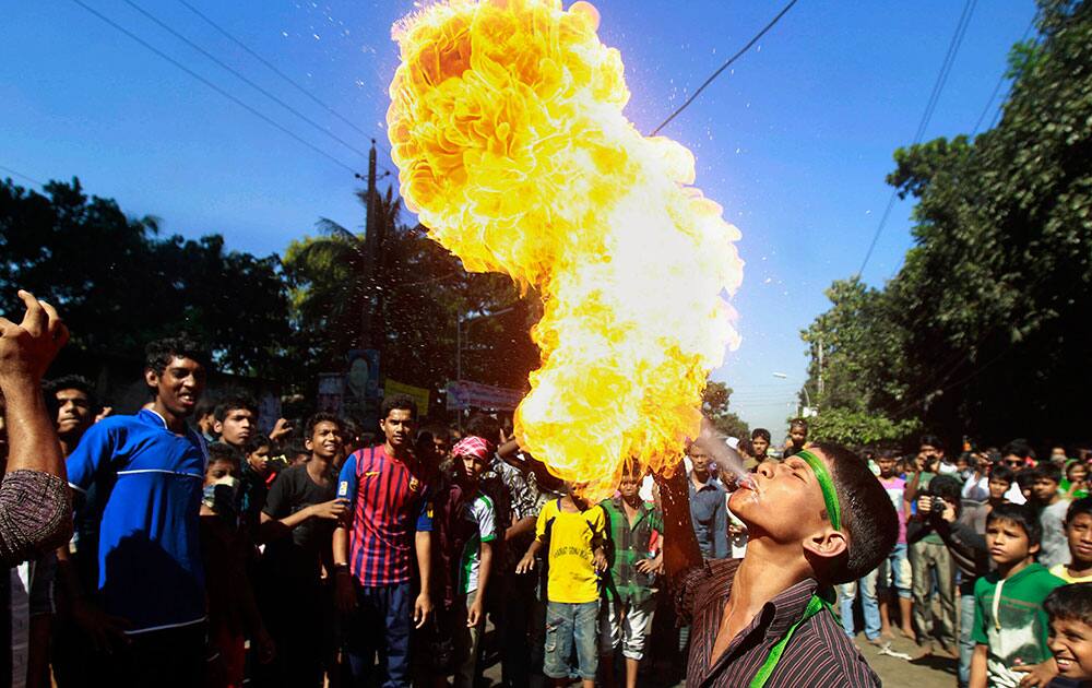 A Bangladeshi Shiite Muslim breathes out fire during Muharram procession in Dhaka, Bangladesh.