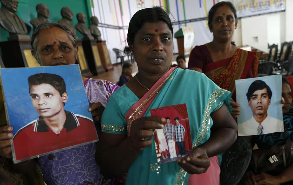 Sri Lankan ethnic Tamils hold portraits of their family members who have disappeared at a gathering organized by the main opposition United National Party (UNP) in Colombo, Sri Lanka.