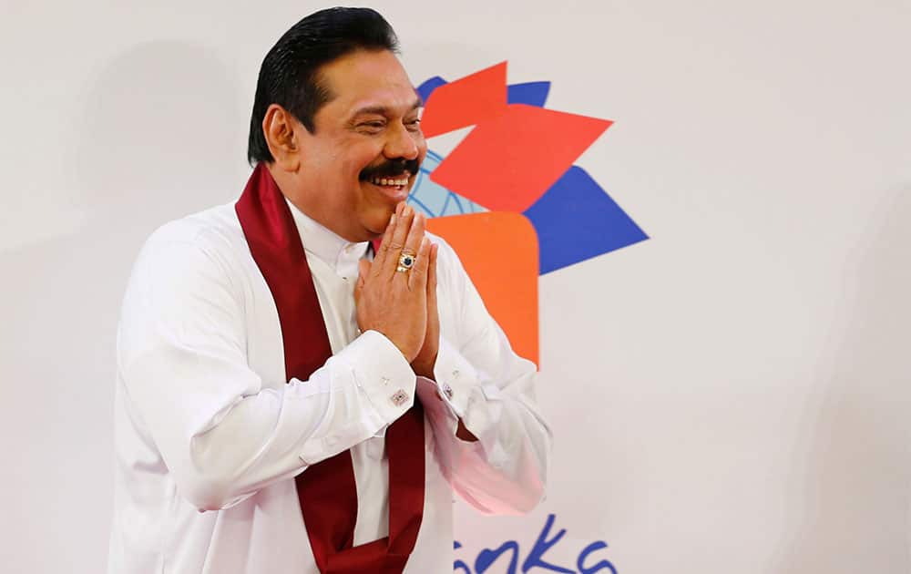 Sri Lankan President Mahinda Rajapaksa greats journalists as he leaves a media briefing a day ahead of Commonwealth Heads of Governments Meeting in Colombo, Sri Lanka.