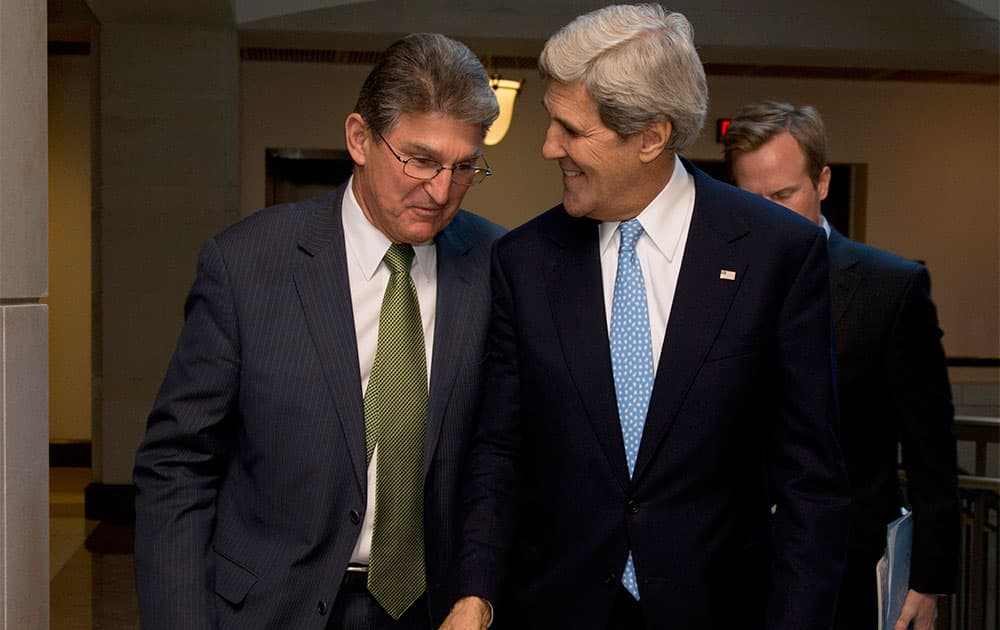 Secretary of State John Kerry walks with Senate Banking Committee member Sen. Joe Manchin, D-W. VA., to a meeting with the committee on Capitol Hill in Washington.