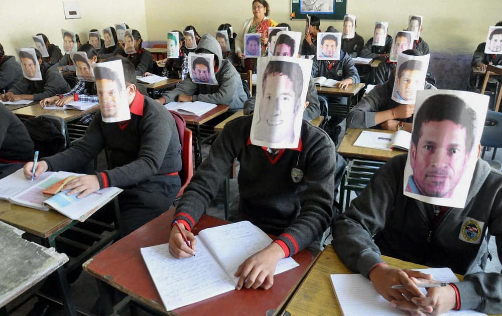 School students fix pictures of Sachin Tendulkar on their faces to pay their respect to him on the eve of Children`s Day in Moradabad.