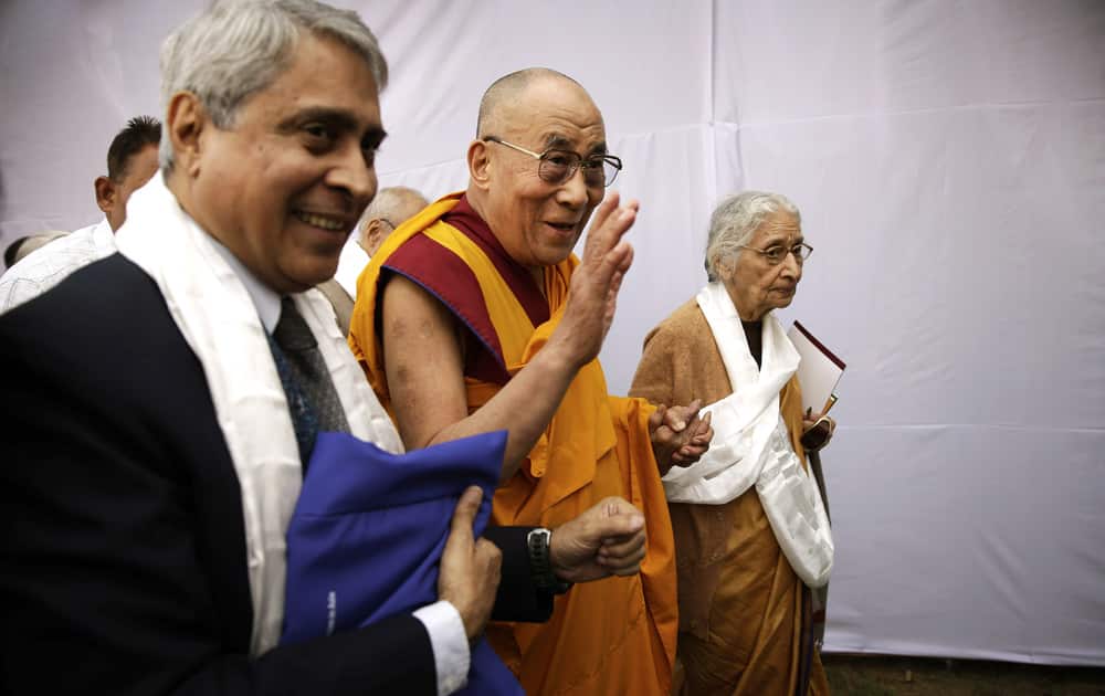 Tibetan spiritual leader, the Dalai Lama waves to his supporters as he attends a seminar on Nalanda Tradition of Buddhism in New Delhi.