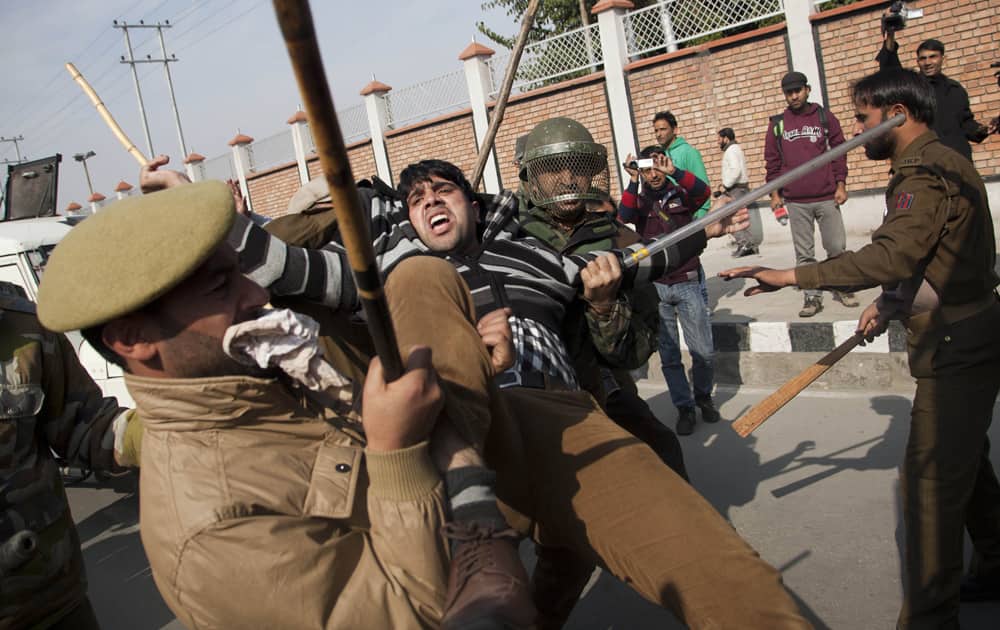 Police men detain Kashmiri Shiite Muslims after they were stopped by police officers during a Muharram procession in Srinagar.
