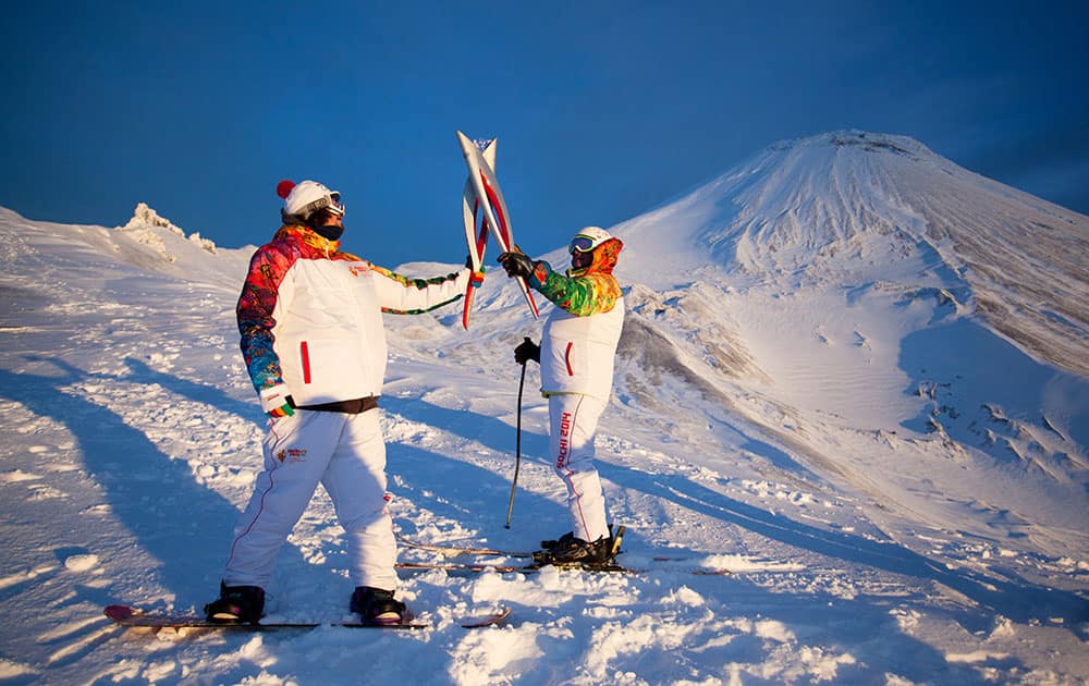 Olympic torch bearers hold Olympic torches during the torch relay at Avachinsky Volcano, on the Kamchtka Peninsula, in Russia.