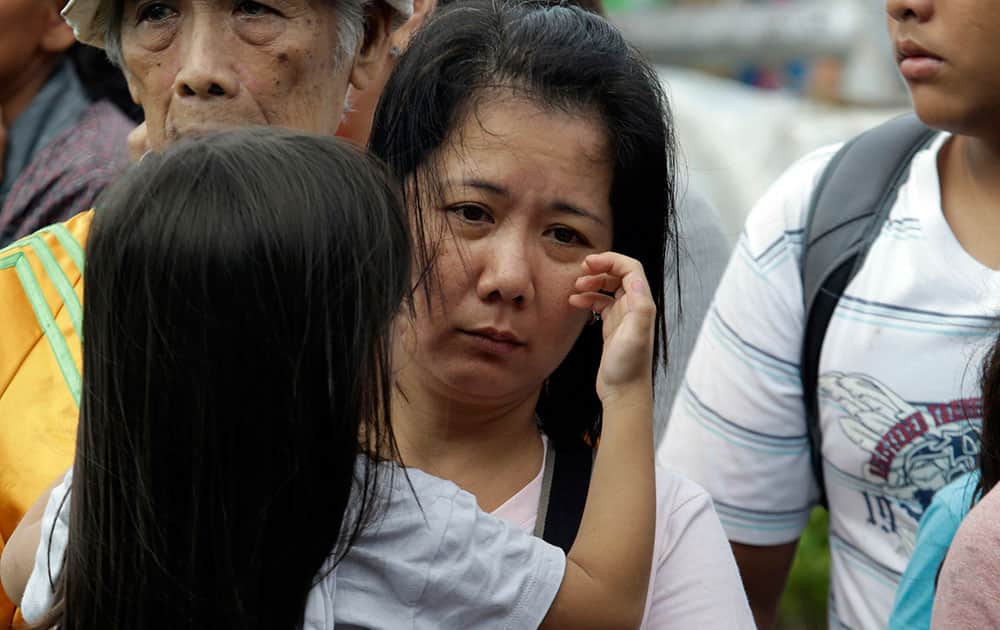 A girl caresses her mother as they queue up to board a military transport plane from the damaged Tacloban airport at Tacloban city, Leyte province in central Philippines.