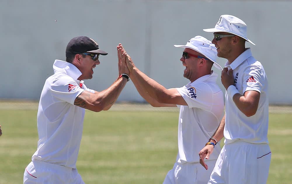 England cricket players Kevin Pietersen, left, and Graeme Swann, center, celebrate after taking the wicket of Cricket Australia`s Invitational Xl player Stuart Broad, right, during their tour match at the SCG in Sydney, Australia.