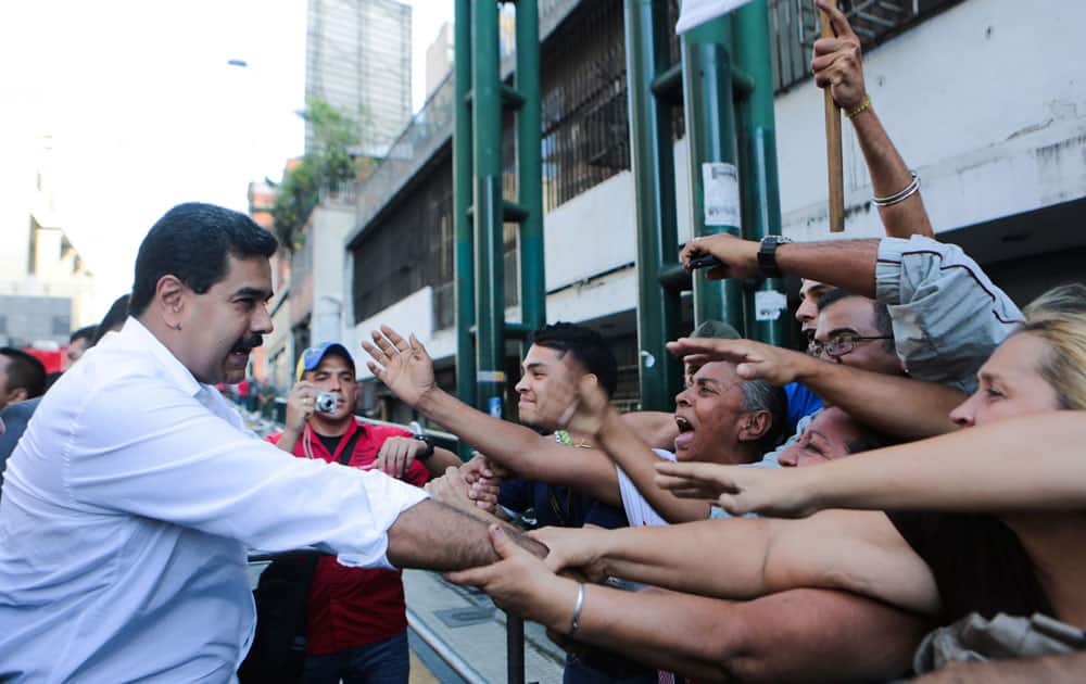 Venezuela`s President Nicolas Maduro shake hands with supporters during a transport workers rally in Caracas, Venezuela.