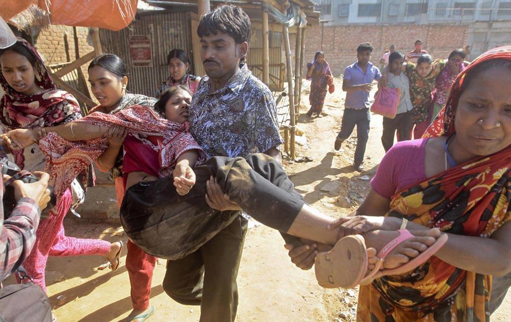 Bangladeshi garment workers assist their colleagues injured during a clash with police in Ashulia, outskirts of Dhaka.